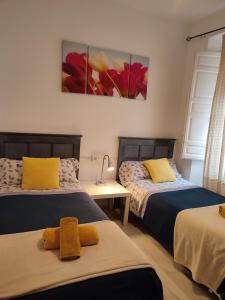 グラナダにあるPríncipe Cのベッドルーム1室(ベッド2台付)が備わります。壁には絵画が飾られています。