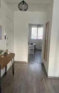 ein leeres Wohnzimmer mit einem Tisch und einer Küche in der Unterkunft Appartement lumineux et traversant in Montauban