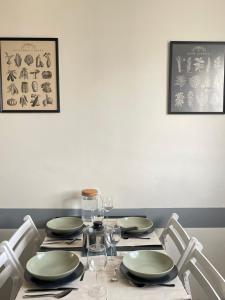 einen Esstisch mit Tellern und Weingläsern in der Unterkunft Appartement lumineux et traversant in Montauban