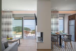 a kitchen and living room with a view of the ocean at Horizon Ionian Villas in Perdika