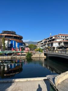 uma pessoa tirando uma foto de um rio com edifícios em Villa Abi Center em Struga