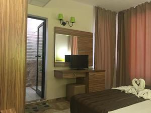 a bedroom with a bed and a desk with a television at Hotel Tm Deluxe located in Sunny Beach in Sunny Beach