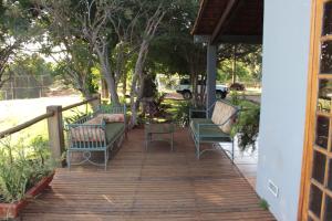 a porch with chairs and tables on a deck at Itaygua Hotel in Ribeirão Preto
