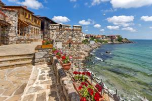 a stone wall with flowers on the beach at Hotel Tm Deluxe located in Sunny Beach in Sunny Beach