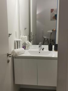 een badkamer met een witte wastafel en een spiegel bij Apto en Punta del Este con Piscina Climatizada!! in Punta del Este