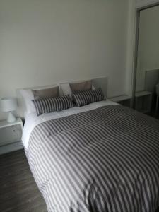um quarto com uma cama grande com lençóis listrados em Apto en Punta del Este con Piscina Climatizada!! em Punta del Este