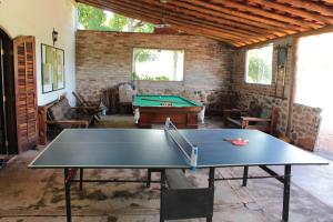 a ping pong table in a room with a pool table at Itaygua Hotel in Ribeirão Preto