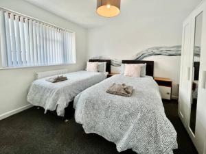 a bedroom with two beds with towels on them at Paddy Whack -A short stroll to Brixham Harbour in Brixham