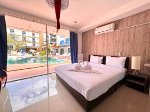 a bedroom with a bed and a large window at Baankasemsuk Resort 般咔 深宿 in Patong Beach