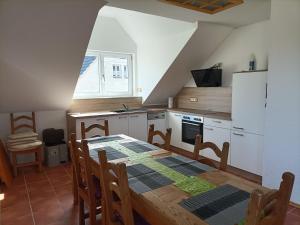 a kitchen with a wooden table and a kitchen with white appliances at Schöne Wohnung mit Whirlpool und Sauna 