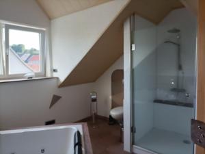 een badkamer op zolder met een douche en een wastafel bij Schöne Wohnung mit Whirlpool und Sauna 