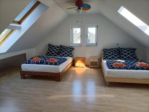 a attic room with two beds and a couch at Schöne Wohnung mit Whirlpool und Sauna 
