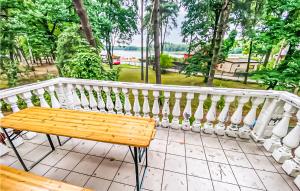 eine Holzbank auf dem Balkon in der Unterkunft Lovely Home In Kamionki Male With Kitchen in Kamionki Małe
