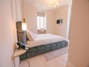 1 dormitorio con 1 cama con sofá verde en Quinta dos Românticos - Charm House & Wine SPA, en Peso da Régua