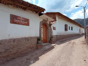 ein Gebäude mit einem Schild an der Straßenseite in der Unterkunft Casona Buenavista Andahuaylillas in Andalmailillas