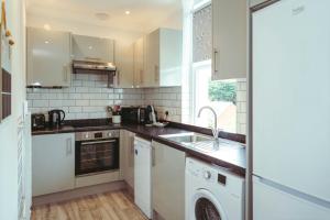 a kitchen with a sink and a dishwasher at Stylish, central, adults-only 1-bed Hideaway in Eastbourne