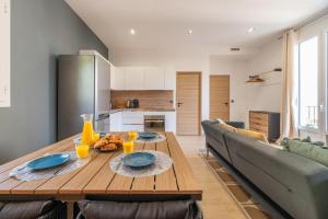 a living room with a wooden table and a couch at SUPERBE APPARTEMENT AVEC BALCON PROCHE MONACO in Beausoleil