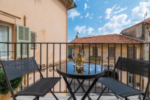 a table and chairs on a balcony with a building at SUPERBE APPARTEMENT AVEC BALCON PROCHE MONACO in Beausoleil