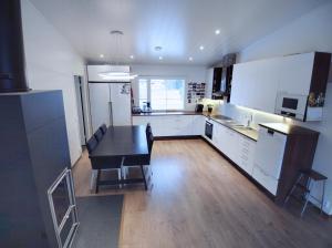 a kitchen with white cabinets and a black table at Renkomäki in Lahti