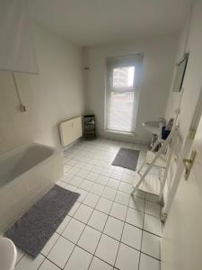 a white bathroom with a tub and a sink at Osthafen IV in Berlin