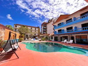 a swimming pool in front of a building at Baankasemsuk Resort 般咔 深宿 in Patong Beach