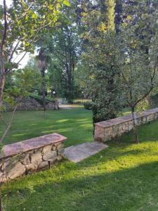 een park met twee stenen banken in het gras bij Villa La Nussa in Capolona