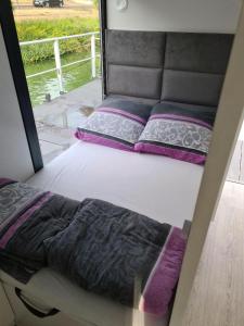 una cama en la parte trasera de una caravana con una ventana en Moselcube, en Traben-Trarbach