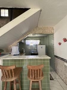 a kitchen with two chairs and a counter in a room at MARAGOGI FLAT BEIRA MAR in Maragogi