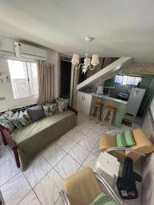 a living room with a couch and a kitchen at MARAGOGI FLAT BEIRA MAR in Maragogi