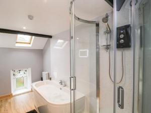 a bathroom with a shower and a tub and a sink at Fellside Cottage in Cockermouth +21 photos