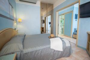 een slaapkamer met een bed met een hoed erop bij Hotel Universo in Lido di Jesolo