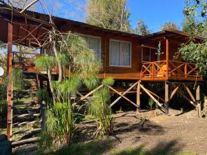 a log cabin with a fence in front of it at Cabaña Magnolia en Marea Delta del Tigre in Tigre