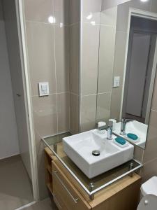 y baño con lavabo blanco y espejo. en Dpto Nva Cba, pileta seguridad, cochera en Córdoba