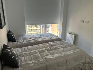 2 camas en un dormitorio con ventana en Dpto Nva Cba, pileta seguridad, cochera en Córdoba