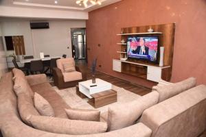 uma sala de estar com um sofá grande e uma televisão em Haut-Standing- Appartement-Fes-City em Fez