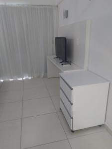 a white room with a television and a white dresser at Porto de Galinhas no Laguna in Porto De Galinhas