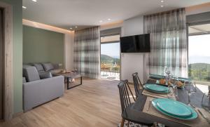 a dining room and living room with a table and chairs at Horizon Ionian Villas in Perdika