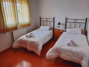 two beds sitting next to each other in a bedroom at Casa rural cascales in Cervera del Llano +21 photos