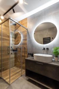 a bathroom with a sink and a shower and a mirror at City Center Sanctuary Modern Studio with Electric Car-Friendly Features in Vilnius in Vilnius