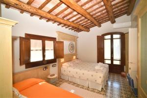 1 dormitorio con 2 camas y techo de madera en Cal Fuster De La Plaça, en Sant Martí de Tous