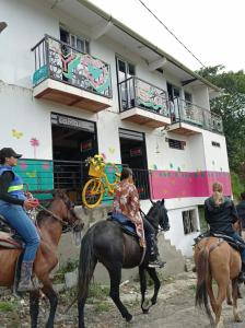 tres personas montando caballos delante de un edificio en Combi en Salento