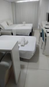 a white room with two beds and a sink at Porto de Galinhas no Laguna in Porto De Galinhas