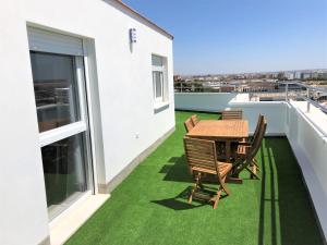 d'une terrasse avec une table et des chaises sur un balcon. dans l'établissement Luxury Attics Plaza Punto PARKING INCLUIDO, à Huelva