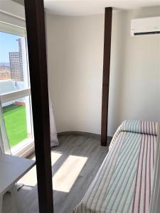 um quarto com uma cama e uma janela em Luxury Attics Plaza Punto PARKING INCLUIDO em Huelva