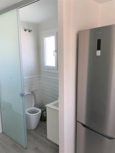 a bathroom with a toilet and a refrigerator at Luxury Attics Plaza Punto PARKING INCLUIDO in Huelva