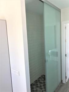 uma porta de duche em vidro numa casa de banho com piso em xadrez em Luxury Attics Plaza Punto PARKING INCLUIDO em Huelva