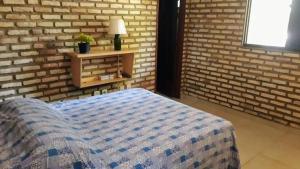 a bedroom with a bed and a brick wall at RECANTO da LAGOA in Jijoca de Jericoacoara +29 photos