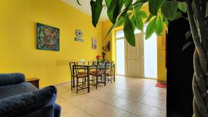 バルセロナにあるApartamento Rosellónの黄色の壁のリビングルーム(テーブル、椅子付)