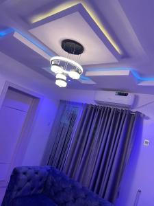 Cette chambre dispose d'un plafond avec des lumières violettes et d'un lit. dans l'établissement GS HOMES, à Lagos