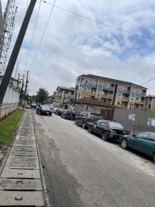une rue avec des voitures garées sur le côté de la route dans l'établissement GS HOMES, à Lagos